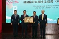 Secretary of the Vinh Long Party Committee Tran Van Lau (second from right) presents a gift to Ehime Governor Tokihiro Nakamura at the MoU signing ceremony on January 12. (Photo: VNA)