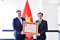 Foreign Minister Le Hoai Trung presents the Friendship Order to US Ambassador Marc Knapper. (Photo: VNA)