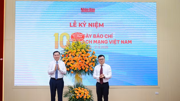 Deputy Secretary of the Party Committee of Central Party Agencies Nguyen Long Hai (L) presents flowers to Nhan Dan Newspaper on the occasion of the 101st anniversary of Viet Nam Revolutionary Press Day