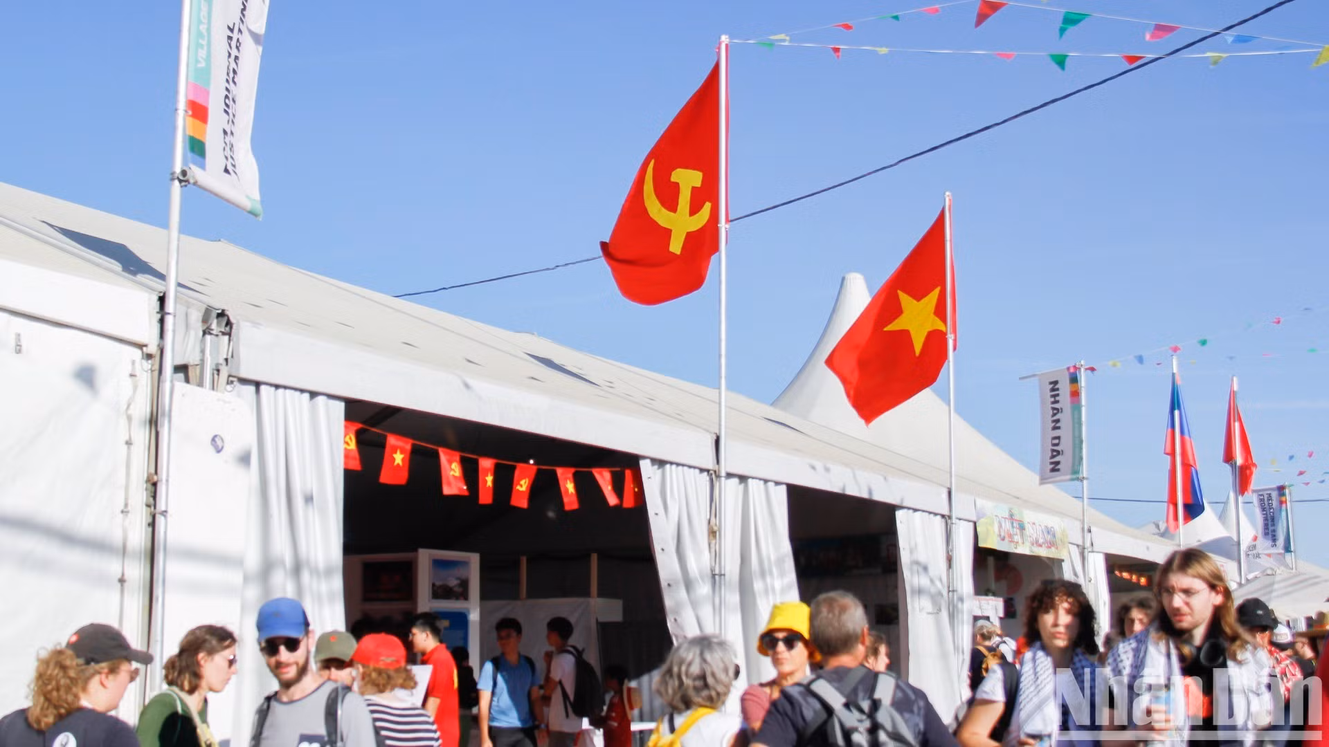 During the three days of the festival, the Vietnamese exhibition space, resplendent in the red of the Party flag and the national flag, was always crowded with visitors. (Photo: KHAI HOAN-TRUNG HUNG)