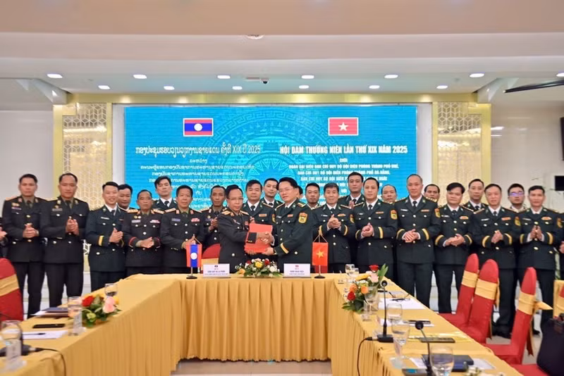 The two sides sign the minutes of the meeting. (Photo: VNA)