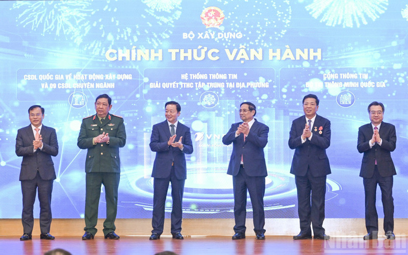 Prime Minister Pham Minh Chinh (third from right) and officials launch the Ministry of Construction’s new information technology systems at the conference on December 21. (Photo: NDO)