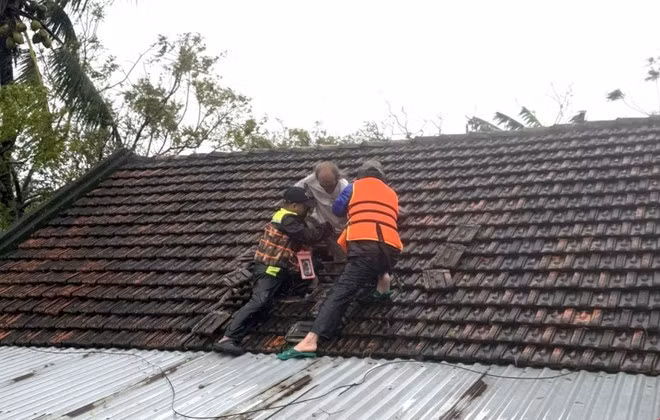 Rescuers assist a resident in a flooded area. (Photo: VNA)