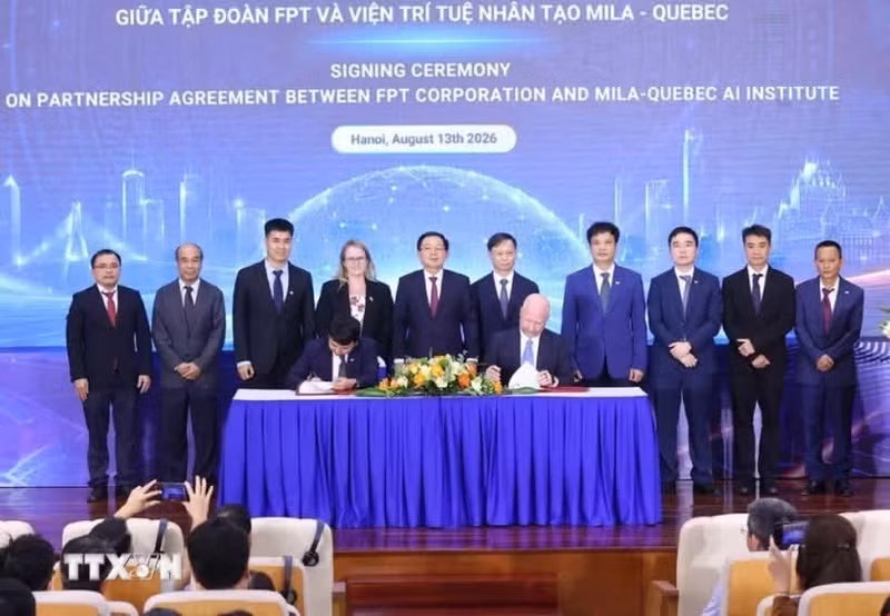 Deputy Prime Minister Ho Quoc Dung (fifth from left) and delegates witness the signing of the strategic cooperation agreement for the next phase between FPT Corporation and Mila – Quebec AI Institute of Canada. (Photo: VNA) 