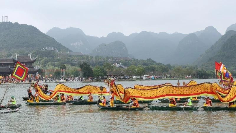 A procession of dragon boats carries sacred water from Tam Chuc Lake to Ngoc Mountain. (Photo: DAO PHUONG)