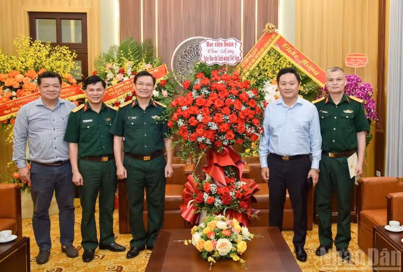 Phan Van Hung, Member of the Standing Board of the Party Committee and Deputy Editor-in-Chief of Nhan Dan Newspaper, receives Colonel Doan Van Mau, Member of the Standing Committee of the Party Committee and Director of the Political Department of the Military Medical Academy.