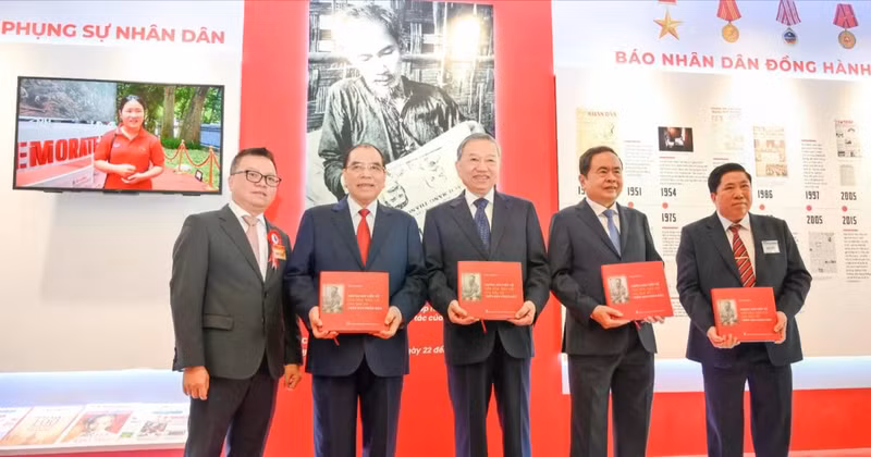 General Secretary To Lam and other Party and State incumbent and former leaders receive the book titled “Uncle Ho’s articles on Culture and Journalism by in Nhan Dan Newspaper” at the Nhan Dan exhibition’s pavilion. 