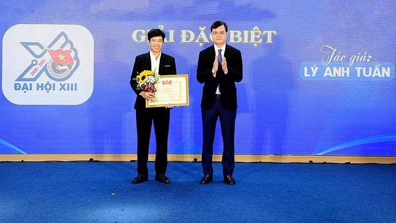 Bui Quang Huy, Member of the Party Central Committee and First Secretary of the Ho Chi Minh Communist Youth Union Central Committee (right), presents the Special Prize of the Logo Design Contest for the 13th National Youth Congress to Ly Anh Tuan.