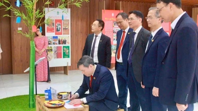 Professor Dr Le Van Loi, President of the Viet Nam Academy of Social Sciences, writes New Year wishes at the display area featuring the ‘cay neu’ (neu pole) – a traditional Vietnamese symbol representing hopes for a peaceful and auspicious year ahead.