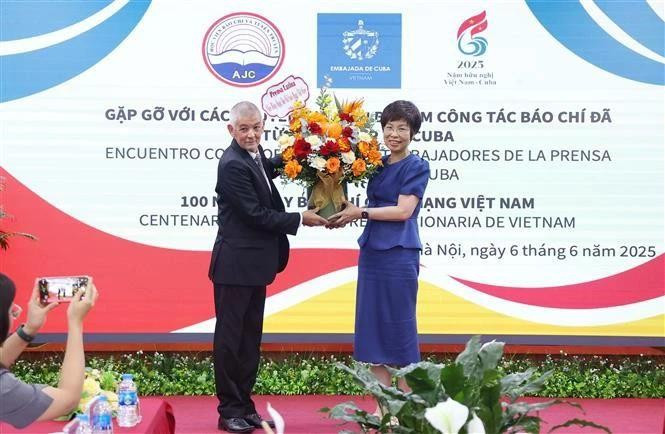 A representative of Prensa Latina News Agency in Viet Nam presents flowers to General Director of the Viet Nam News Agency Vu Viet Trang to congratulate the agency on the occasion of the 100th anniversary of Vietnamese Revolutionary Press Day. (Photo: VNA) 