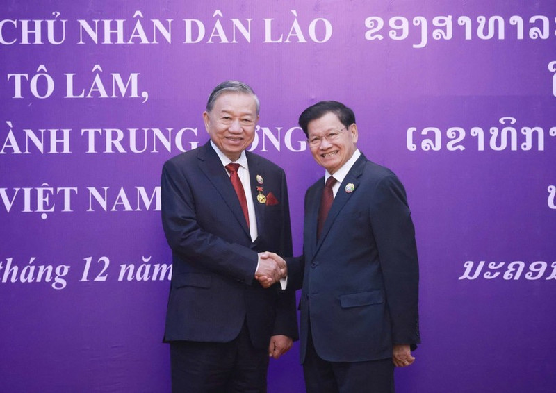 General Secretary of the Central Committee of the Lao People's Revolutionary Party and President of Laos Thongloun Sisoulith (right) congratulates General Secretary of the Central Committee of the Communist Party of Viet Nam To Lam on receiving the National Gold Medal - the highest honour of Laos (Photo: VNA)