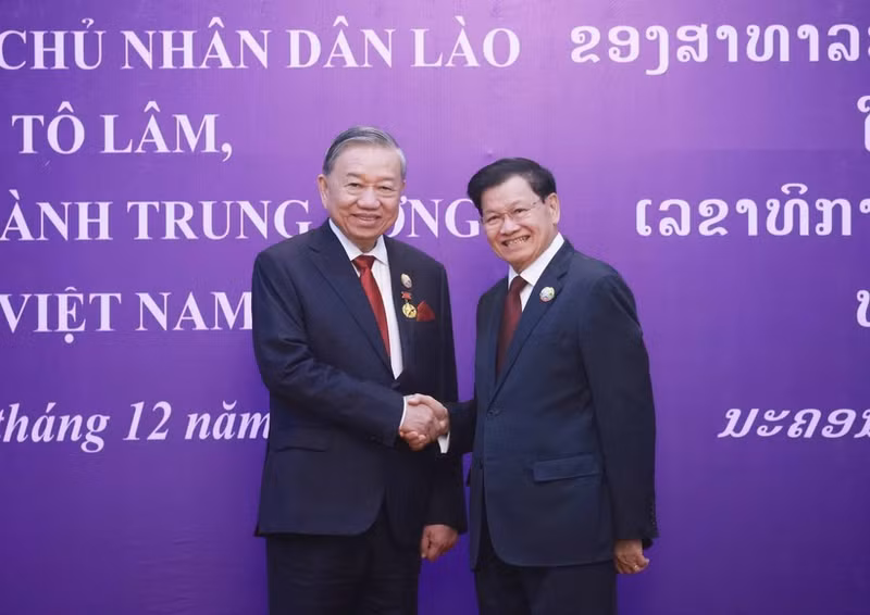 General Secretary of the Central Committee of the Lao People's Revolutionary Party and President of Laos Thongloun Sisoulith (right) congratulates General Secretary of the Central Committee of the Communist Party of Viet Nam To Lam on receiving the National Gold Medal - the highest honour of Laos (Photo: VNA)