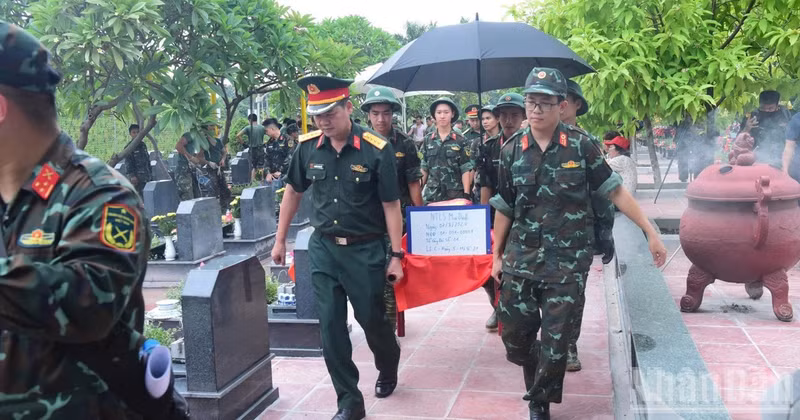 Officers and soldiers transport unidentified martyrs’ remains at Mai Dich Cemetery in Phu Dien Ward to the sampling area. (Photo: HUU THU)