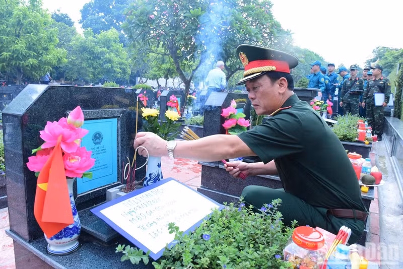 Major General Dao Van Nhan, Member of the Standing Board of the Ha Noi Municipal Party Committee and Commander of the Ha Noi Capital Command, respectfully offers incense at the graves of unidentified martyrs. (Photo: HUU THU)