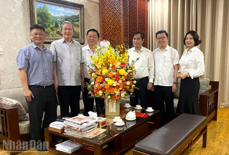 Politburo member Nguyen Trong Nghia congratulates journalist Dinh The Huynh. (Photo: VAN TOAN)