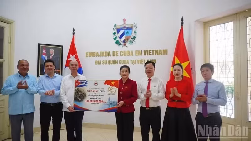 President of the Viet Nam Red Cross Society's Central Committee Do Thi Thu Thao (fourth, right) hands over the token of 100 billion VND in aid to Cuban Ambassador to Viet Nam Rogelio Polanco Fuentes (third, left) at the ceremony on August 11. (Photo: NDO) 