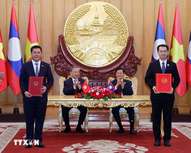 Party General Secretary of Viet Nam To Lam and Party General Secretary and President of Laos Thongloun Sisoulith witness the exchange of an MoU on the industrial chain development on December 1. (Photo: VNA)