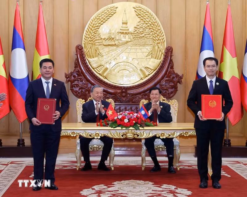 Party General Secretary of Viet Nam To Lam and Party General Secretary and President of Laos Thongloun Sisoulith witness the exchange of an MoU on the industrial chain development on December 1. (Photo: VNA)
