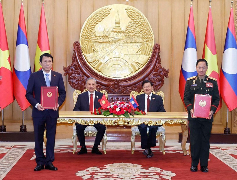 Vietnamese Party General Secretary To Lam (second, left), and Party General Secretary and President of Laos Thongloun Sisoulith witness the exchange of memorandum of understanding (MoU) on cooperation between the Vietnamese Ministry of Public Security and the Lao Ministry of National Defence on building a Viet Nam - Laos friendship road. (Photo: VNA)