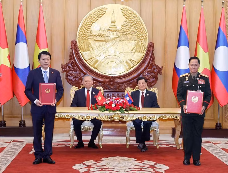 Vietnamese Party General Secretary To Lam (second, left), and Party General Secretary and President of Laos Thongloun Sisoulith witness the exchange of memorandum of understanding (MoU) on cooperation between the Vietnamese Ministry of Public Security and the Lao Ministry of National Defence on building a Viet Nam - Laos friendship road. (Photo: VNA)