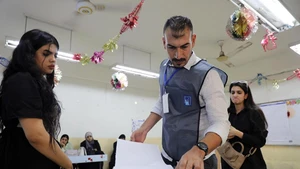 A staff member assists voters to put their ballots into a ballot box at a polling center in Baghdad, Iraq, on Nov. 11, 2025. Iraqis began to vote in parliamentary elections on Tuesday morning for a new 329-member Council of Representatives. (Photo: Xinhua)