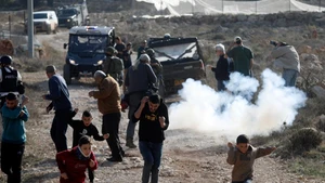 Palestinians take shelter from tear gases fired by Israeli forces in the village of Tarqumiyah, west of Hebron in the West Bank, on Nov. 28, 2025. Israeli security forces and settlers have killed 1,030 Palestinians in the occupied West Bank, including East Jerusalem, since Oct. 7, 2023, the United Nations Office of the High Commissioner for Human Rights (OHCHR) has verified, a UN spokesperson said here Friday. (Photo: Xinhua)