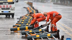 Staff members remove lane dividers pushed over by strong gusts in a street in Haikou, south China's Hainan Province, on Oct. 5, 2025. Typhoon Matmo, the 21st named storm of the 2025 Pacific typhoon season, is intensifying as it nears south China's coastal areas, leading to large-scale evacuations. The island province of Hainan has relocated over 197,000 people from high-risk areas as of Sunday noon, with a typhoon red alert remaining in effect. (Photo: Xinhua)
