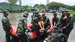 Indonesian army members transfer a woman from a dinghy to a wheelchair after heavy rain hit Semarang, Central Java, Indonesia, Oct. 25, 2025. (Photo: Xinhua)