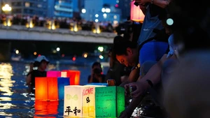 People place paper lanterns on a river at Hiroshima Peace Memorial Park in Hiroshima, Japan, on Aug. 6, 2025. The Japanese city of Hiroshima on Wednesday held a ceremony at the Peace Memorial Park to commemorate the 80th anniversary of the atomic bombing, while citizens gathered at the Hiroshima Atomic Bomb Dome to criticize the government's ongoing military buildup policies. (Photo: Xinhua)
