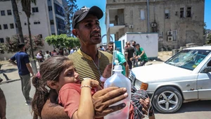 A wounded Palestinian girl is carried by a man at a hospital following an Israeli airstrike in Gaza City, on July 13, 2025. At least 58 Palestinians were killed by Israeli airstrikes and gunfire across the Gaza Strip on Sunday, Palestinian sources said. (Photo: Xinhua)
