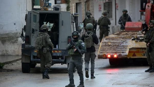 Members of Israeli forces stand guard as an Israeli bulldozer demolishes a house in the town of Bizzariya, northwest of Nablus in the West Bank, on Dec. 24, 2025. (Photo: Xinhua)