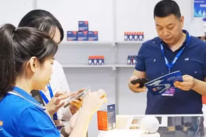 Customers use smartphones to access product information through QR codes. Photo: NAM ANH