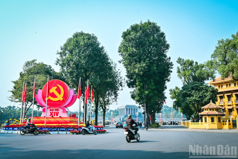 At the Dien Bien Phu–Doc Lap–Chu Van An intersection, decorative clusters featuring the hammer-and-sickle symbol of the Party flag alongside the National Flag are arranged in a harmonious and solemn manner.