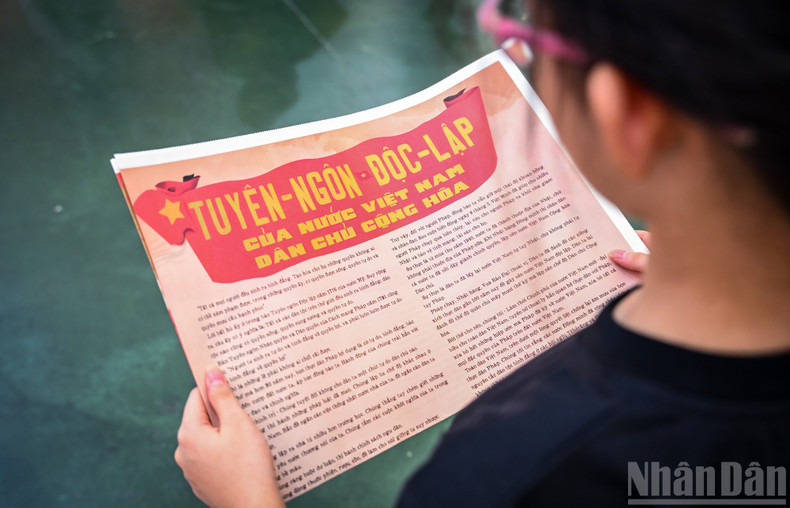 Children attentively studying the special content of the Nhan Dan Newspaper supplement.