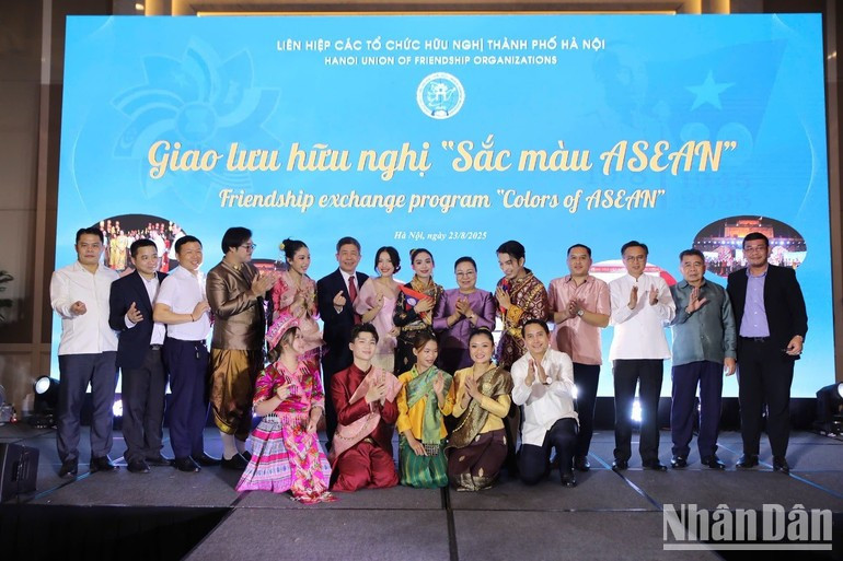 Delegates viewed photos and paintings displayed at the programme. (Photo: KHANH LAN) ndo-br-sacmau1.jpg