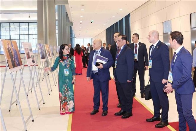 International delegates visit a photo exhibition by the Viet Nam News Agency, within the signing ceremony of the United Nations Convention against Cybercrime in Ha Noi on the morning of October 25, 2025. (Photo: VNA) signing2.jpg