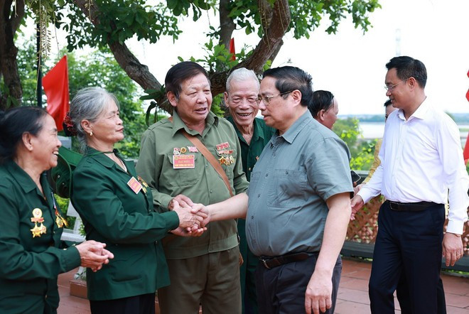 Prime Minister Pham Minh Chinh meets with former youth volunteers and frontline workers at the Truong Son Martyrs Memorial Temple - Long Dai Ferry Terminal site. (Photo: VNA) Prime Minister Pham Minh Chinh meets with former youth volunteers and frontline workers at the Truong Son Martyrs Memorial Temple - Long Dai Ferry Terminal site. (Photo: VNA)