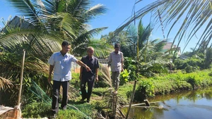 Nam Dau (middle) and local officials visit the site to resolve the conflict over land between two households.