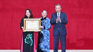 Party General Secretary To Lam presents the title of Hero of the People's Armed Forces to the family representatives of Senior Lieutenant General Bui Thien Ngo. (Photo: Dang Khoa)