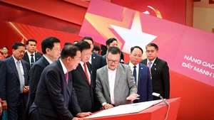 Deputy Prime Minister Mai Van Chinh, Party General Secretary and President of Laos Thongloun Sisoulith, and President of the Cambodian People’s Party and President of the Cambodian Senate Hun Sen visit a space of the Nhan Dan Newspaper at the exhibition on September 2. (Photo: NDO) 