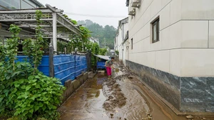 A woman clears mud after flood recedes in Beijing, China. (Photo: Xinhua)