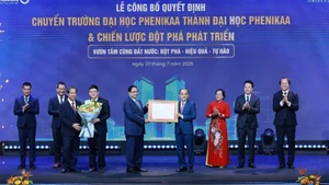 Prime Minister Pham Minh Chinh (fifth, right) hands over the Government’s decision allowing Phenikaa University to expand from a multi-disciplinary institution into a university with multiple member schools across various fields. (Photo: VNA) 