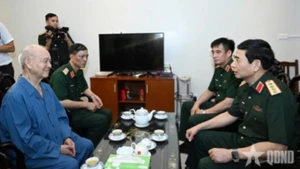 Minister of Defence Phan Van Giang inquires after former Defence Minister Pham Van Tra. (Photo: QDND)