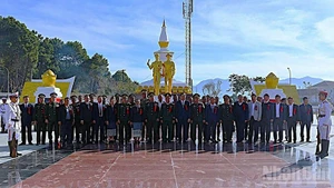 Delegates pose for a photo in front of the Laos-Viet Nam fighting alliance monument in Xaysomboun Province. (Photo: Duy Toan)
