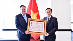 Foreign Minister Le Hoai Trung presents the Friendship Order to US Ambassador Marc Knapper. (Photo: VNA)