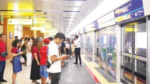 Passengers wait to board a train of Metro Line 1 (Ben Thanh-Suoi Tien Line).
