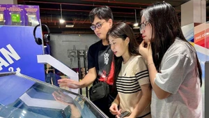 Readers experience e-books at the exhibition on national achievements at the Viet Nam Exposition Centre in Dong Anh, Ha Noi.