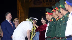 US officers and sailors are greeted with flowers. (Photo: VNA)