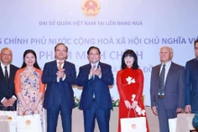 PM Pham Minh Chinh (centre) presents gifts to the Vietnamese community in Russia at the meeting in Moscow on late March 22 (local time). (Photo: VNA)