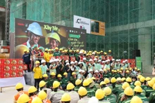 Representatives of units and contractors share the joy with workers at the construction site.